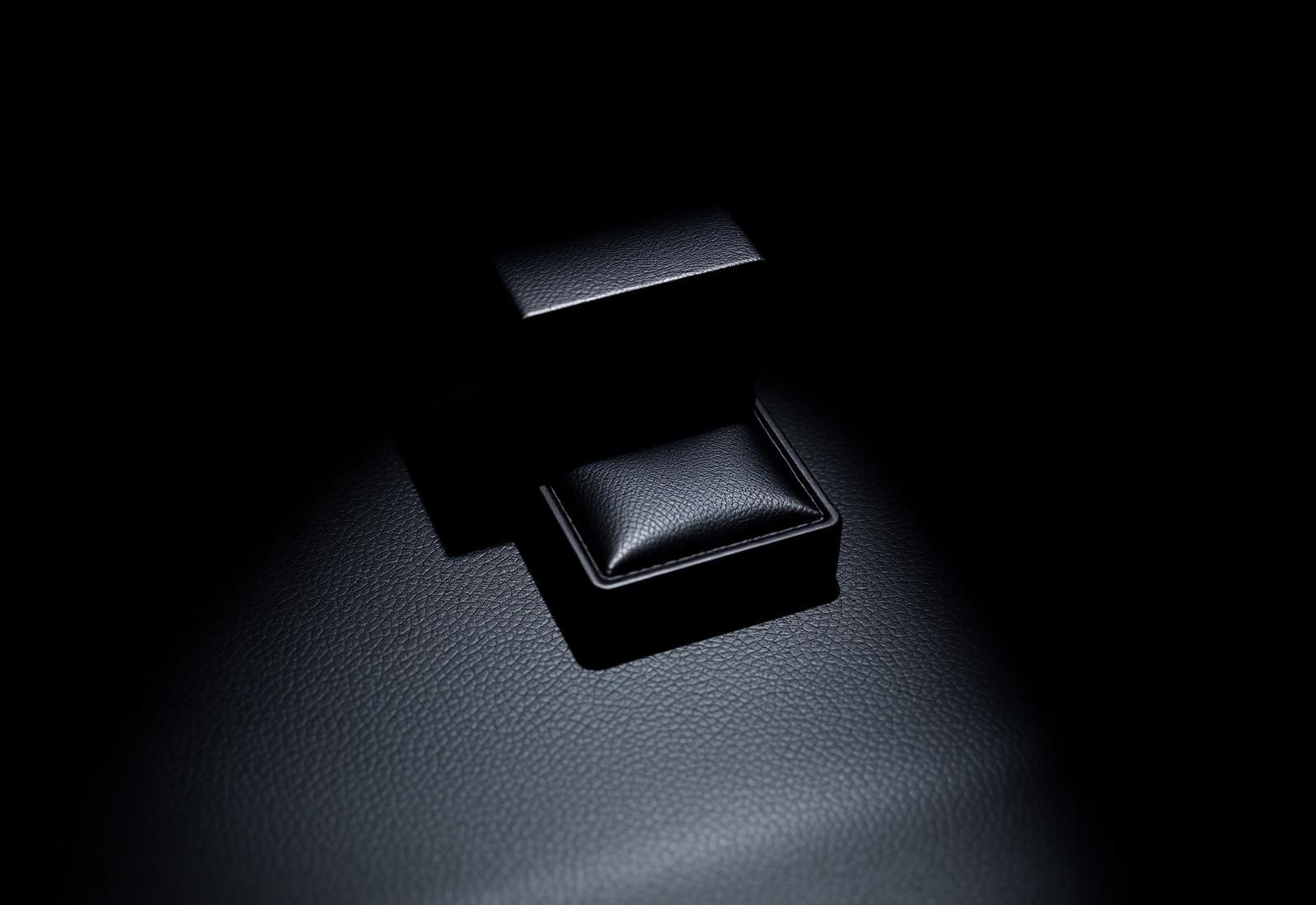 Estojo de joia em couro preto com iluminação dramática lateral